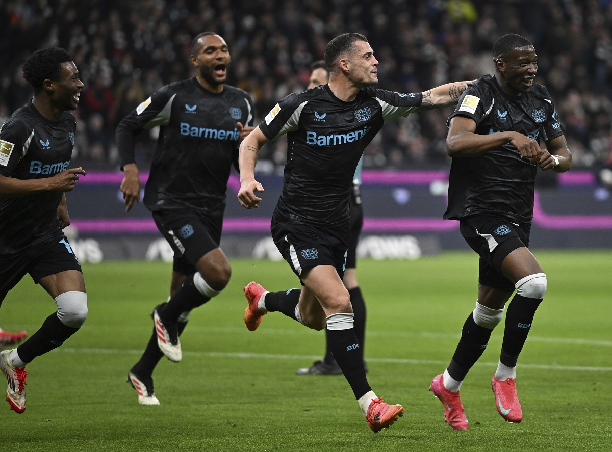 Leverkusen's scorer Nordi Mukiele, right, and his teammates celebrate their side's second goal during the German Bundesliga soccer match between Eintracht Frankfurt and Bayer Leverkusen in Frankfurt, Germany, Saturday, March 1, 2025. (Arne Dedert/dpa via AP)