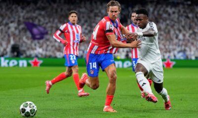 Spain Soccer Champions League Atletico Madrid's Marcos Llorente, left, fights for the ball with Real Madrid's Vinicius Junior during the Champions League round of 16 first leg soccer match between Real Madrid and Atletico Madrid at the Bernebeu stadium in Madrid, Spain, Tuesday, March 4, 2025. (AP Photo/Manu Fernandez)