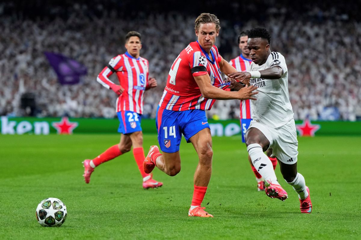 Spain Soccer Champions League Atletico Madrid's Marcos Llorente, left, fights for the ball with Real Madrid's Vinicius Junior during the Champions League round of 16 first leg soccer match between Real Madrid and Atletico Madrid at the Bernebeu stadium in Madrid, Spain, Tuesday, March 4, 2025. (AP Photo/Manu Fernandez)