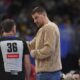 Injured Denver Nuggets center Nikola Jokic, center, confers with referee Brent Barnaky in the second half of an NBA basketball game against the Chicago Bulls, Monday, March 24, 2025, in Denver. (AP Photo/David Zalubowski)