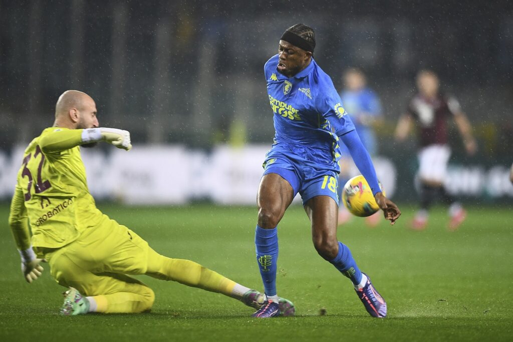 Empoli's Christian Kouame, right, challenges for the ball with Torino's goalkeeper Vanja Milinkovic-Savic during the Serie A soccer match between Torino and Empoli at the Stadio Olimpico Grande Torino in Turin, Italy, Saturday, March 15, 2025. (Alberto Gandolfo/LaPresse via AP)