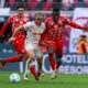 Leipzig's Xavi Simons, left, and Mainz's Danny da Costa, right, challenge for the ball during the German Bundesliga soccer match between RB Leipzig and FSV Mainz 05 in Leipzig, Germany, Saturday, March 1, 2025. (Jan Woitas/dpa via AP)