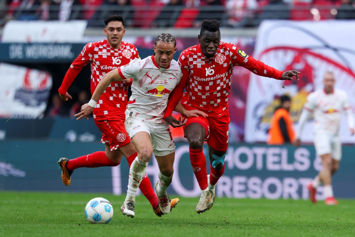 Leipzig's Xavi Simons, left, and Mainz's Danny da Costa, right, challenge for the ball during the German Bundesliga soccer match between RB Leipzig and FSV Mainz 05 in Leipzig, Germany, Saturday, March 1, 2025. (Jan Woitas/dpa via AP)