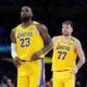 Los Angeles Lakers' LeBron James (23) and Luka Doncic (77) watch action during the second half of an NBA basketball game against the New Orleans Pelicans Tuesday, March 4, 2025, in Los Angeles. (AP Photo/Jae C. Hong)