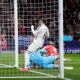 Players react after Atletico Madrid's Conor Gallagher, on the ground, scored the opening goal during the Champions League round of 16, second leg, soccer match between Atletico Madrid and Real Madrid at the Metropolitano stadium in Madrid, Spain, Wednesday, March 12, 2025. (AP Photo/Manu Fernandez)