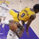 Los Angeles Lakers guard Bronny James, top, falls over Milwaukee Bucks guard Gary Trent Jr. as Trent Jr. tries to shoot during the first half of an NBA basketball game Thursday, March 20, 2025, in Los Angeles. (AP Photo/Mark J. Terrill)