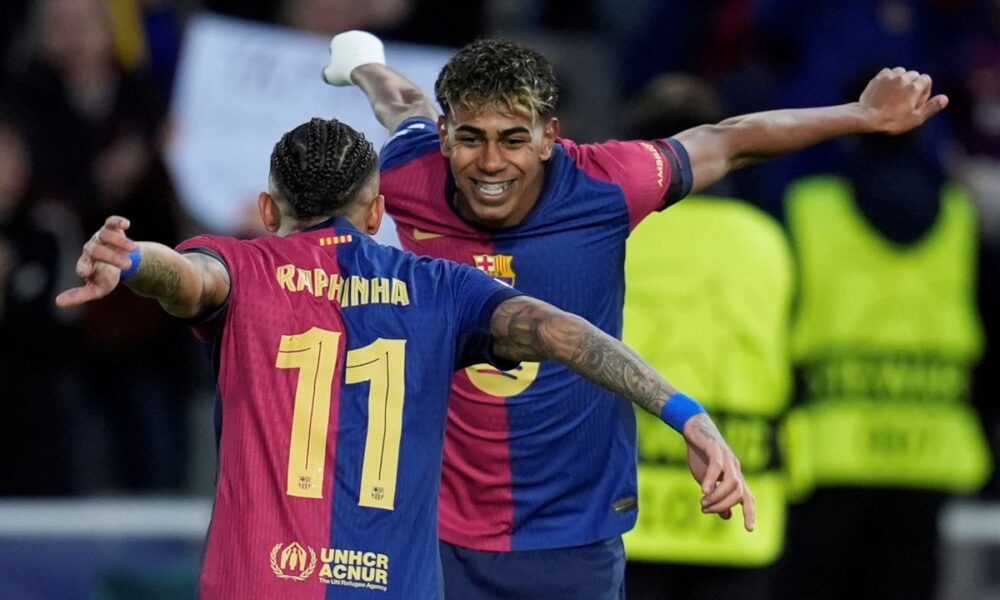 Barcelona's Raphinha, left, celebrates with his teammate Lamine Yamal after scoring his side's opening goal during the Champions League round of 16 second leg soccer match between FC Barcelona and SL Benfica at the Lluis Companys Olympic Stadium in Barcelona, Spain, Tuesday, March 11, 2025. (AP Photo/Emilio Morenatti)