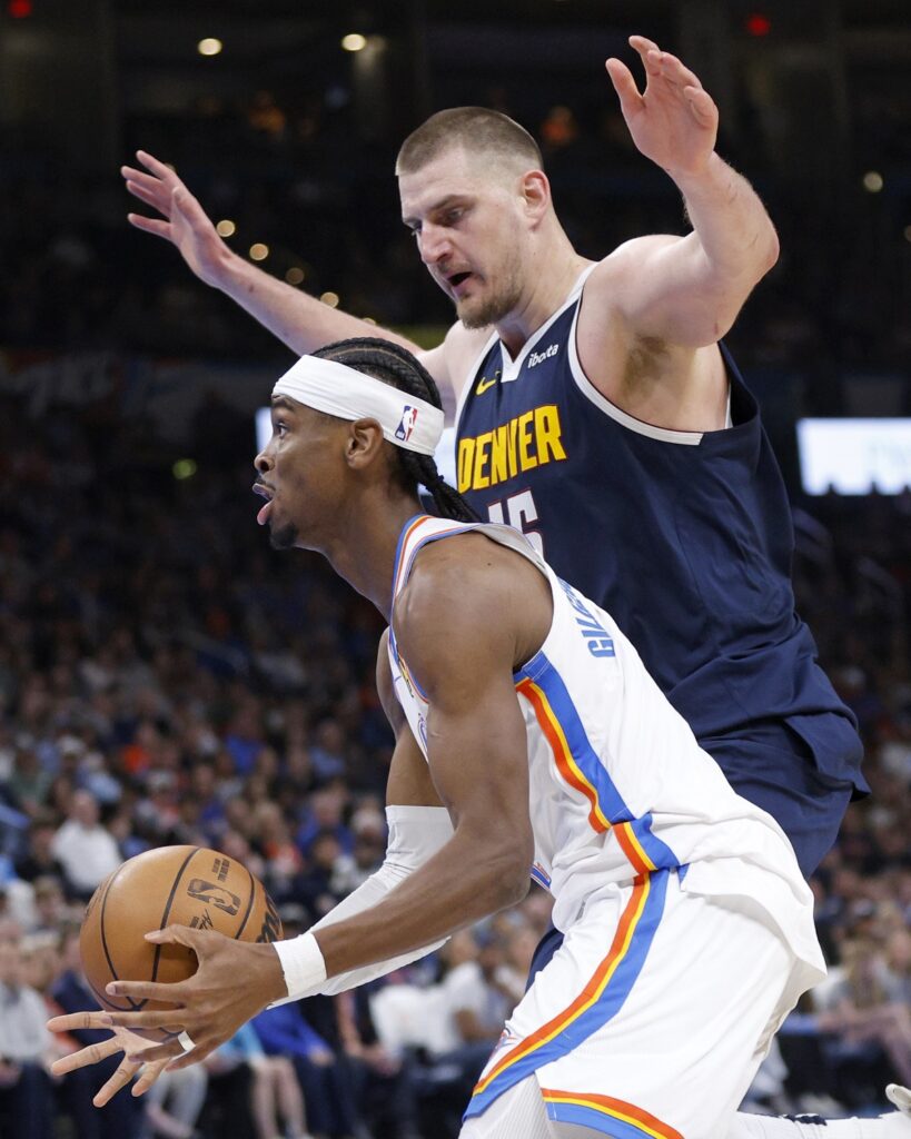 Oklahoma City Thunder guard Shai Gilgeous-Alexander, left, drives in front of Denver Nuggets center Nikola Jokic, right, during the first half of an NBA basketball game Monday, March 10, 2025, in Oklahoma City. (AP Photo/Nate Billings)