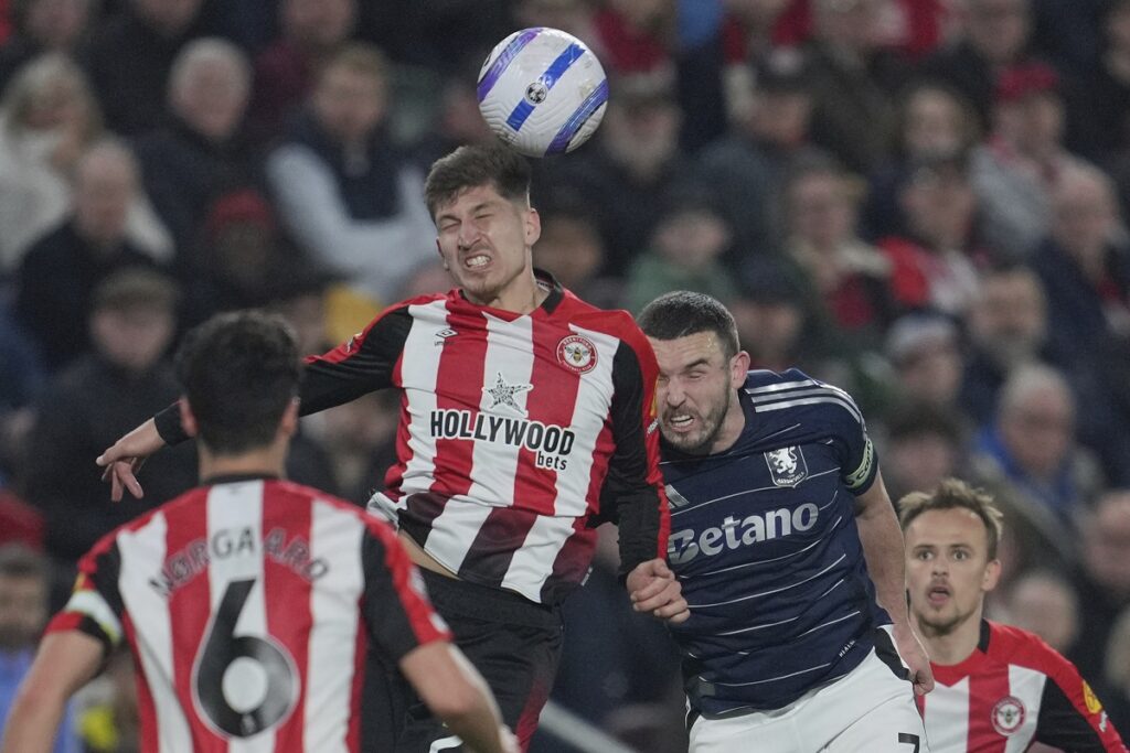 Brentford's Vitaly Janelt, left leaps to head the ball under pressure from Aston Villa's John McGinn during the English Premier League soccer match between Brentford and Aston Villa at the Gtech Community stadium in London, Saturday, March 8, 2025. (AP Photo/Kin Cheung)