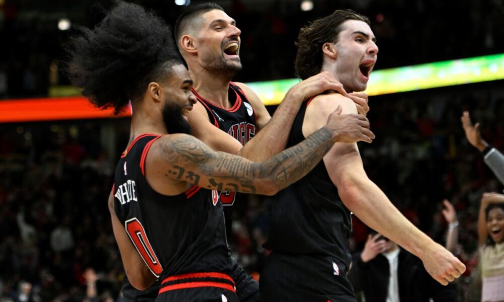 Chicago Bulls' Josh Giddey right, celebrates with teammates Nikola Vucevic center, and Coby White left, after making the winning basket against the Los Angeles Lakers in an NBA basketball game Thursday, March 27, 2025, in Chicago. (AP Photo/Paul Beaty)