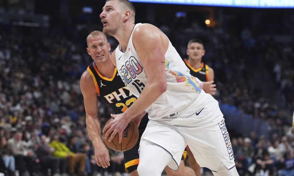 Denver Nuggets center Nikola Jokic, front, drives past Phoenix Suns center Mason Plumlee in the first half of an NBA basketball game Friday, March 7, 2025, in Denver. (AP Photo/David Zalubowski)