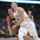 Denver Nuggets center Nikola Jokic, front, drives past Phoenix Suns center Mason Plumlee in the first half of an NBA basketball game Friday, March 7, 2025, in Denver. (AP Photo/David Zalubowski)