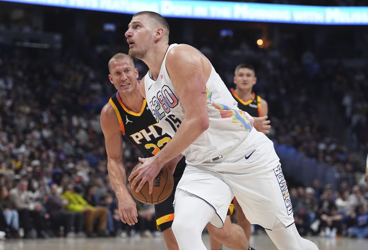 Denver Nuggets center Nikola Jokic, front, drives past Phoenix Suns center Mason Plumlee in the first half of an NBA basketball game Friday, March 7, 2025, in Denver. (AP Photo/David Zalubowski)