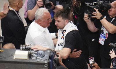 Sasa Doncic, center left in white, hugs his son, Los Angeles Lakers' Luka Doncic, center right, after the team's NBA basketball game against the Dallas Mavericks in Dallas, Wednesday, April 9, 2025. (AP Photo/Julio Cortez)