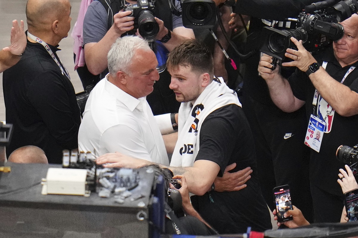 Sasa Doncic, center left in white, hugs his son, Los Angeles Lakers' Luka Doncic, center right, after the team's NBA basketball game against the Dallas Mavericks in Dallas, Wednesday, April 9, 2025. (AP Photo/Julio Cortez)