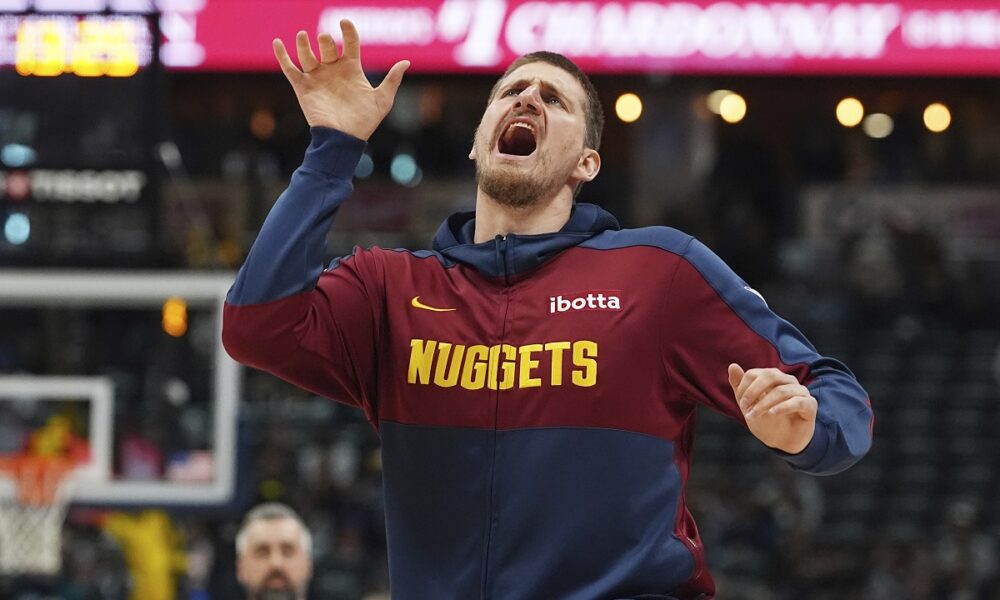 Denver Nuggets center Nikola Jokic jokes with teammates as they warm up to face the Indiana Pacers in the first half of an NBA basketball game Sunday, April 6, 2025, in Denver. (AP Photo/David Zalubowski)