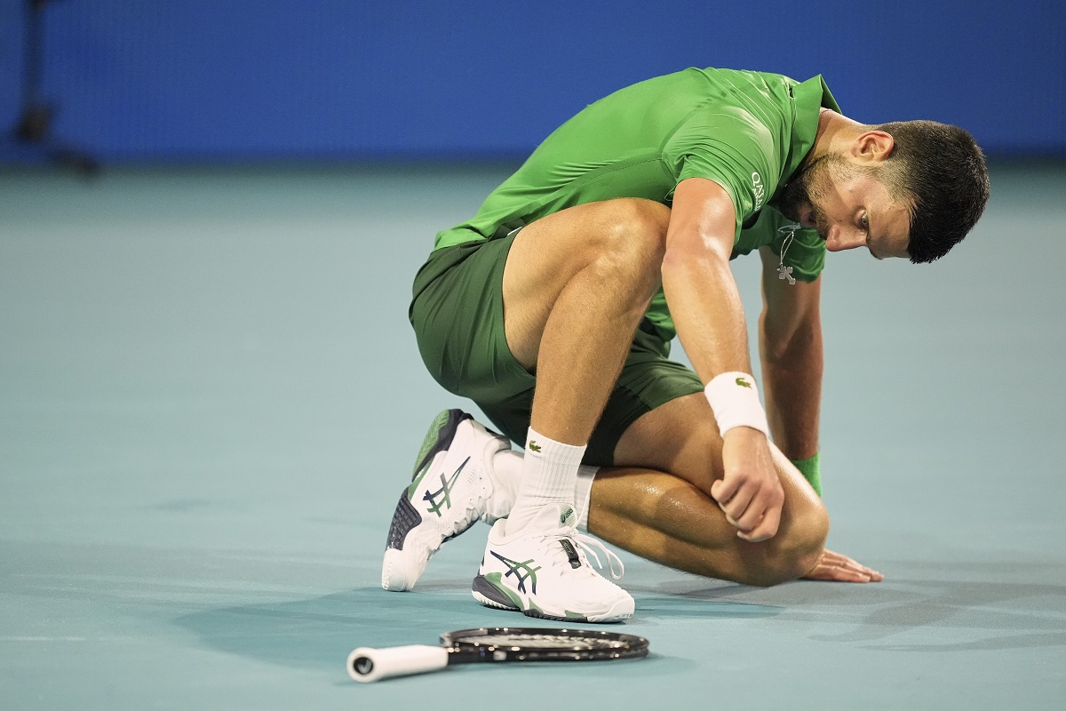 Novak Djokovic, of Serbia, gets up after collapsing on the court, as he plays Jakub Mensik, of Czech Republic, in the men's singles final match at the Miami Open tennis tournament, Sunday, March 30, 2025, in Miami Gardens, Fla. (AP Photo/Rebecca Blackwell)