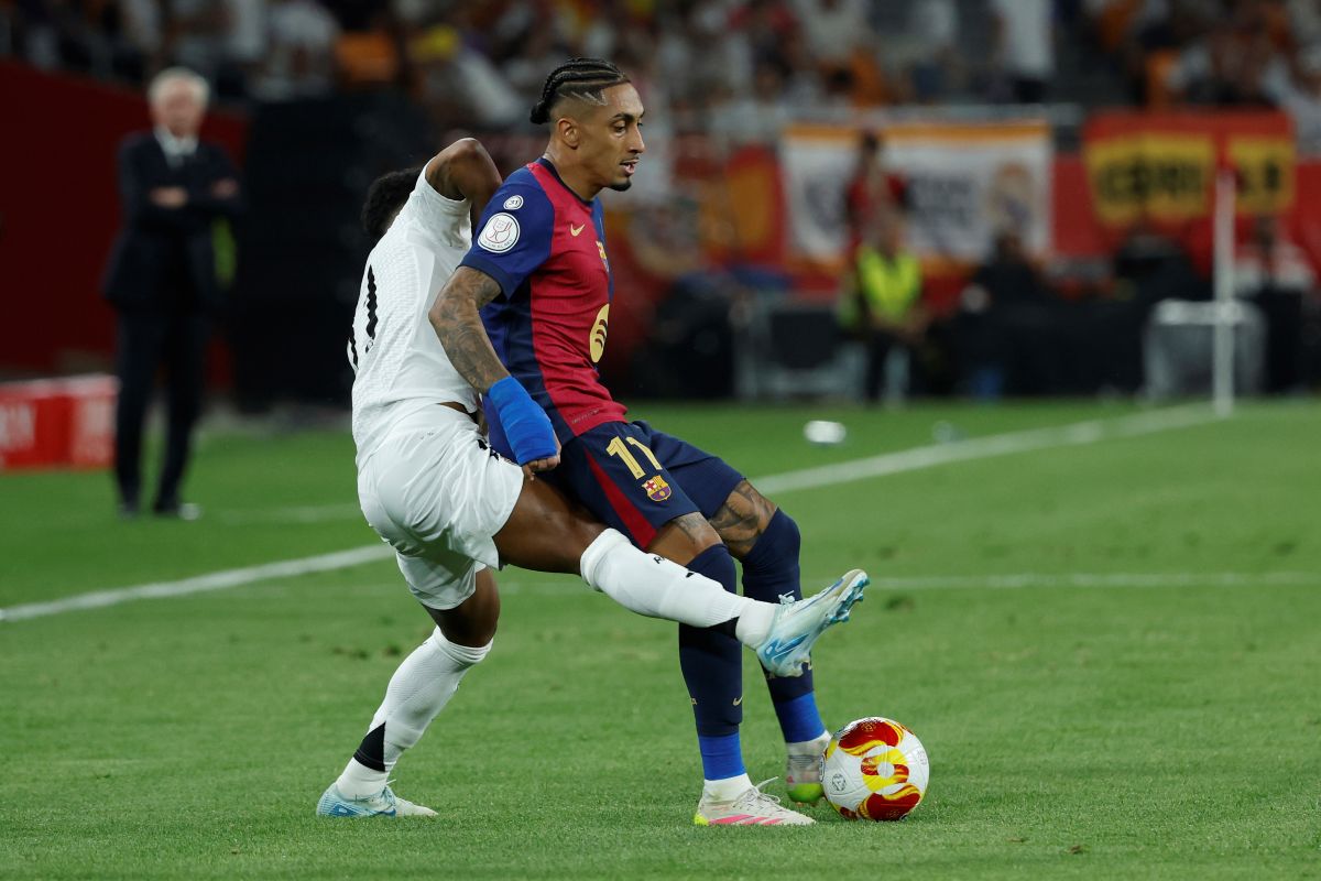 Barcelona's Raphinha, right, is challenged by Real Madrid's Rodrygo during the Spanish Copa del Rey final soccer match between Barcelona and Real Madrid at Estadio de La Cartuja stadium in Seville, Spain, Saturday, April 26, 2025. (AP Photo/Joan Monfort)