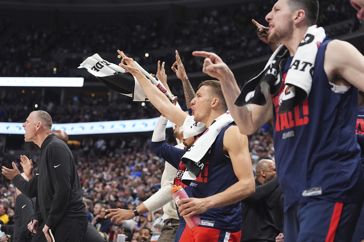 Los Angeles Clippers guard Bogdan Bogdanovic, center, joins teammates in celebrating after a 3-point basket by guard Norman Powell in the second half of Game 2 of a first-round NBA playoff series against the Denver Nuggets, Monday, April 21, 2025, in Denver. (AP Photo/David Zalubowski)