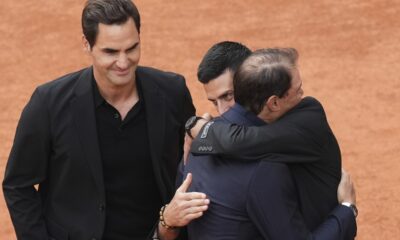 Rafa Nadal, second right, is hugged by Novak Djokovic as Roger Federer, left, look at them, during a farewell ceremony at center court Philippe-Chatrier, at the Roland-Garros stadium, in Paris, Sunday May 25, 2025. (AP Photo/Christophe Ena)