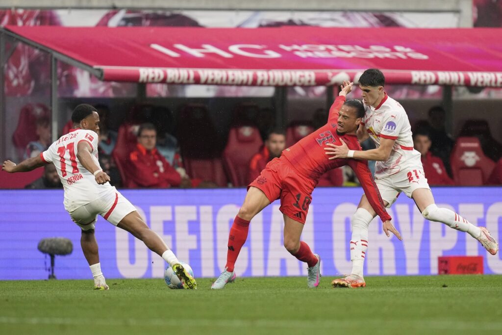 Bayern's Leroy Sane vies for the ball with Leipzig's Lois Openda, left, and Kosta Nedeljkovic during the German Bundesliga soccer match between RB Leipzig and FC Bayern Munich at the Red Bull Arena in Leipzig, Germany, Saturday, May 3, 2025. (AP Photo/Matthias Schrader)