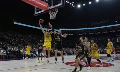 Fenerbahce's Marko Guduric, left, goes for a layup as Monaco's Nick Calathes tries to block him during the Euroleague final basketball match between Monaco and Fenerbahce in Abu Dhabi, United Arab Emirates, Sunday, May 25, 2025. (AP Photo/Altaf Qadri)