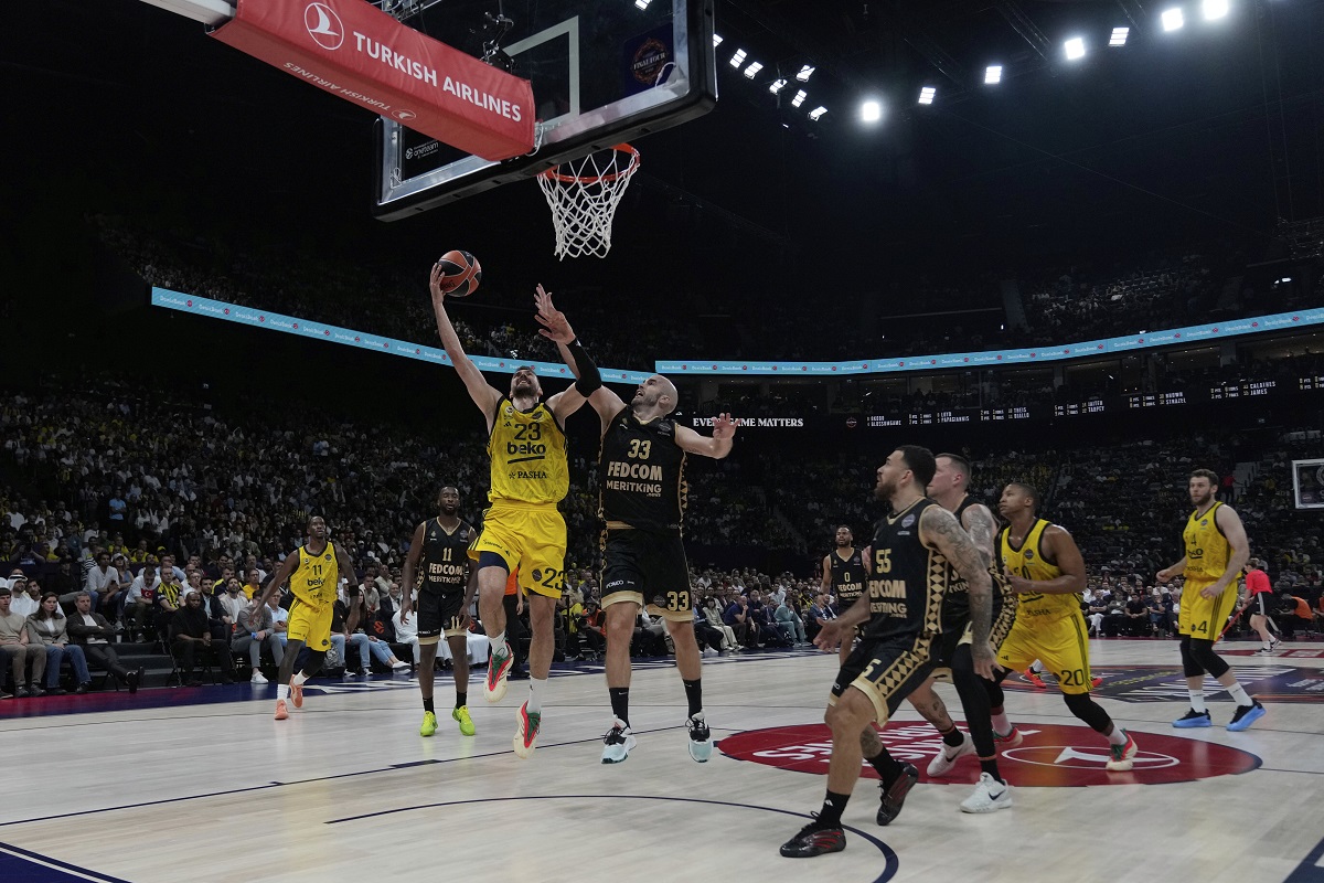 Fenerbahce's Marko Guduric, left, goes for a layup as Monaco's Nick Calathes tries to block him during the Euroleague final basketball match between Monaco and Fenerbahce in Abu Dhabi, United Arab Emirates, Sunday, May 25, 2025. (AP Photo/Altaf Qadri)