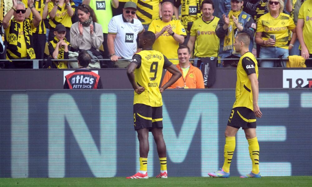 Dortmund's Serhou Guirassy, left, celebrates his after scoring with teammate Waldemar Anton during the German Bundesliga soccer match between Borussia Dortmund and Holstein Kiel at Signal Iduna Park in Dortmund, Germany, Saturday, May 17, 2025. (Bernd Thissen/dpa via AP)