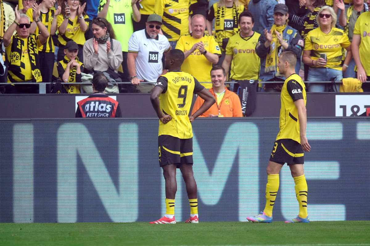 Dortmund's Serhou Guirassy, left, celebrates his after scoring with teammate Waldemar Anton during the German Bundesliga soccer match between Borussia Dortmund and Holstein Kiel at Signal Iduna Park in Dortmund, Germany, Saturday, May 17, 2025. (Bernd Thissen/dpa via AP)
