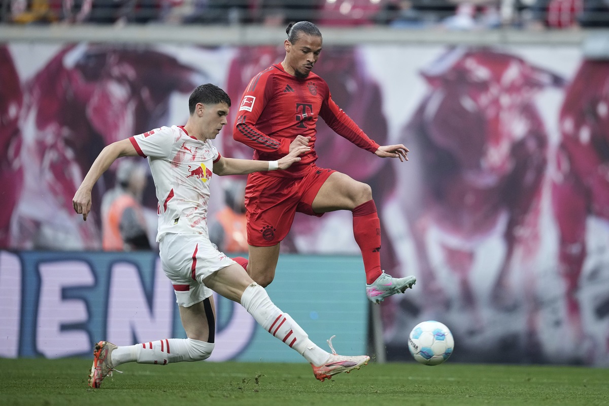 Leipzig's Kosta Nedeljkovic, left, challenges for the ball with Bayern's Leroy Sane during the German Bundesliga soccer match between RB Leipzig and FC Bayern Munich at the Red Bull Arena in Leipzig, Germany, Saturday, May 3, 2025. (AP Photo/Ebrahim Noroozi)