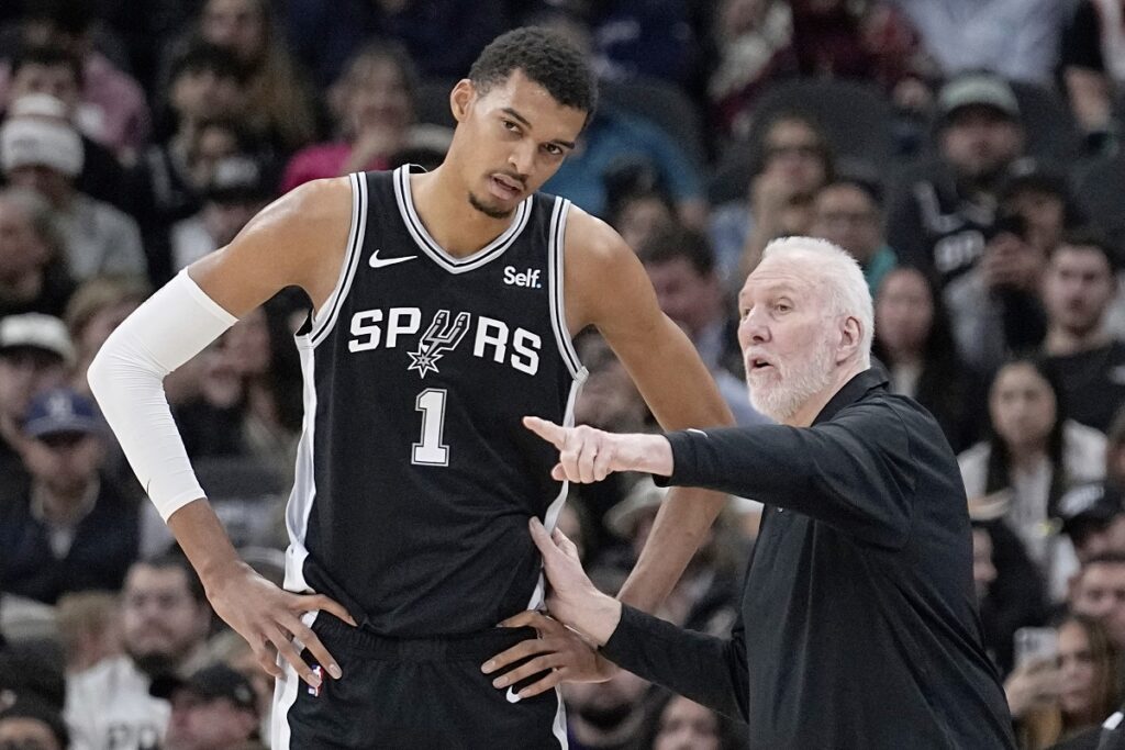 FILE - San Antonio Spurs head coach Gregg Popovich, right, talks with center Victor Wembanyama (1) during the first half of an NBA basketball game against the Los Angeles Lakers in San Antonio, Wednesday, Dec. 13, 2023. (AP Photo/Eric Gay, File)