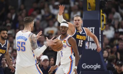 Oklahoma City Thunder center Isaiah Hartenstein (55) fields a pass from guard Shai Gilgeous-Alexander (2) as Denver Nuggets center Nikola Jokic, right, defends in the first half of Game 4 in the Western Conference semifinals of the NBA basketball playoffs Sunday, May 11, 2025, in Denver. (AP Photo/David Zalubowski)