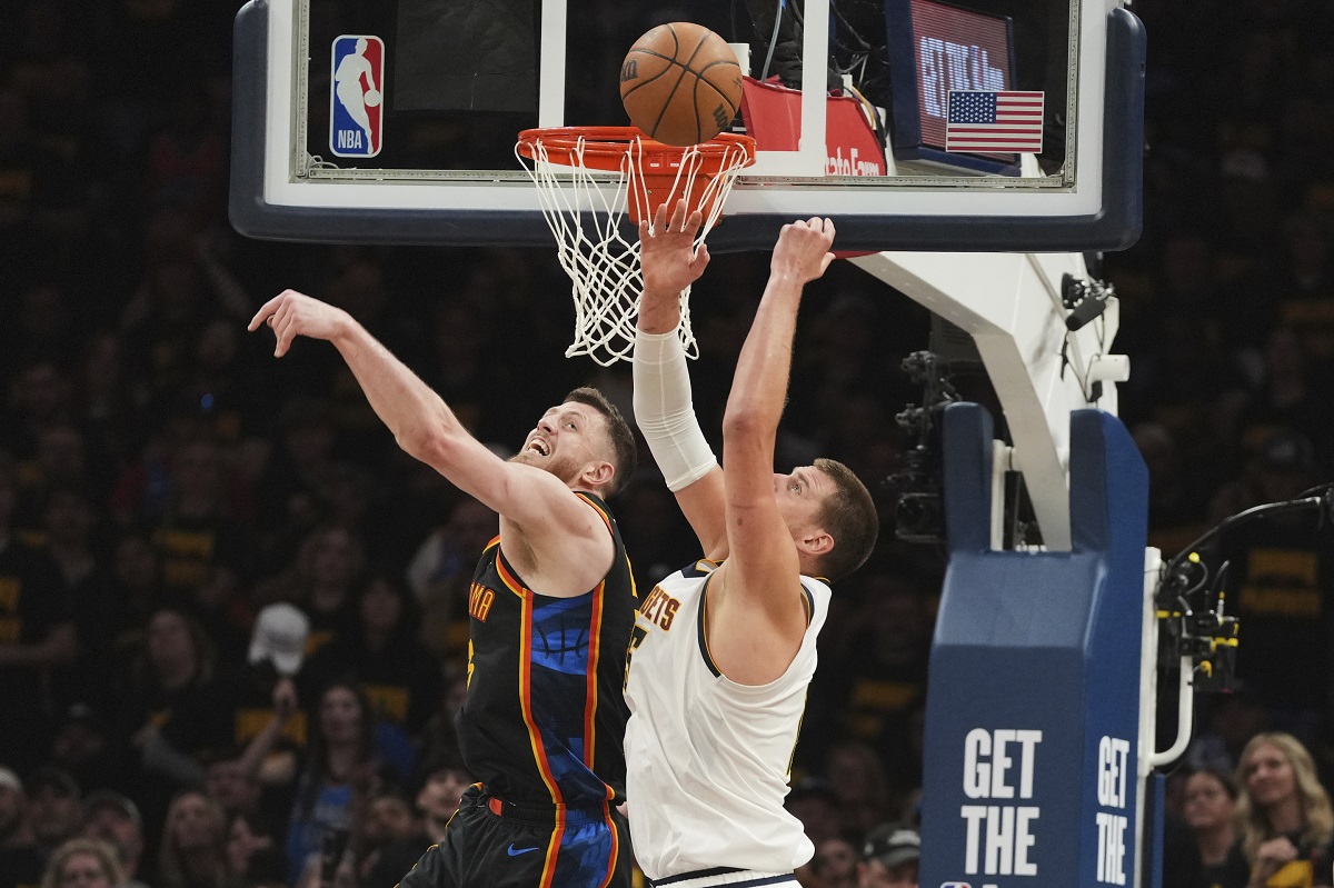 Oklahoma City Thunder's Isaiah Hartenstein, left, and Denver Nuggets' Nikola Jokic, right, compete for a rebound in the first half of Game 2 in the conference semifinals of the NBA basketball playoffs, Wednesday, May 7, 2025, in Oklahoma City. (AP Photo/Kyle Phillips)