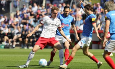Kiel's Magnus Knudsen, right, and Kiel's Steven Skrzybski, second right, challenge for the ball during the German Bundesliga soccer match between Holstein Kiel and SC Freiburg in Kiel, Germany, Saturday, May 10, 2025. (Claus Bergmann/dpa via AP)