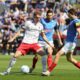 Kiel's Magnus Knudsen, right, and Kiel's Steven Skrzybski, second right, challenge for the ball during the German Bundesliga soccer match between Holstein Kiel and SC Freiburg in Kiel, Germany, Saturday, May 10, 2025. (Claus Bergmann/dpa via AP)