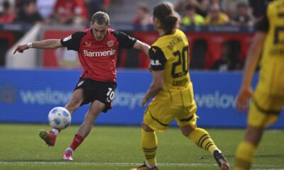 Leverkusen's Florian Wirtz, left, plays the ball during the German Bundesliga soccer match between Bayer 04 Leverkusen and Borussia Dortmund in Leverkusen, Germany, Sunday, May 11, 2025. (Marius Becker/dpa via AP)