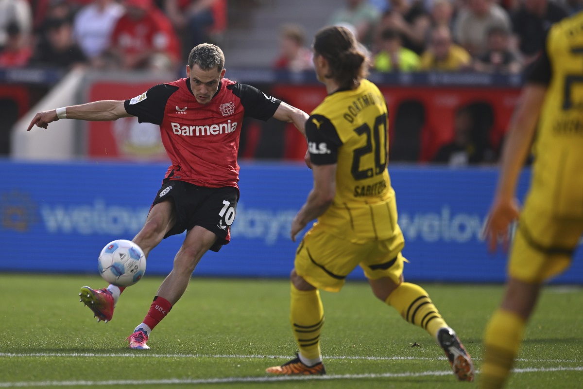 Leverkusen's Florian Wirtz, left, plays the ball during the German Bundesliga soccer match between Bayer 04 Leverkusen and Borussia Dortmund in Leverkusen, Germany, Sunday, May 11, 2025. (Marius Becker/dpa via AP)