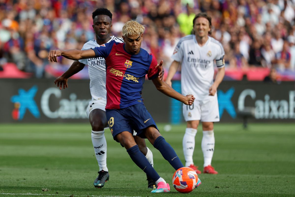Barcelona's Lamine Yamal shoots in front of Real Madrid's Vinicius Junior during the La Liga soccer match between Barcelona and Real Madrid in Barcelona, Spain, Sunday, May 11, 2025. AP Photo/Joan Monfort)