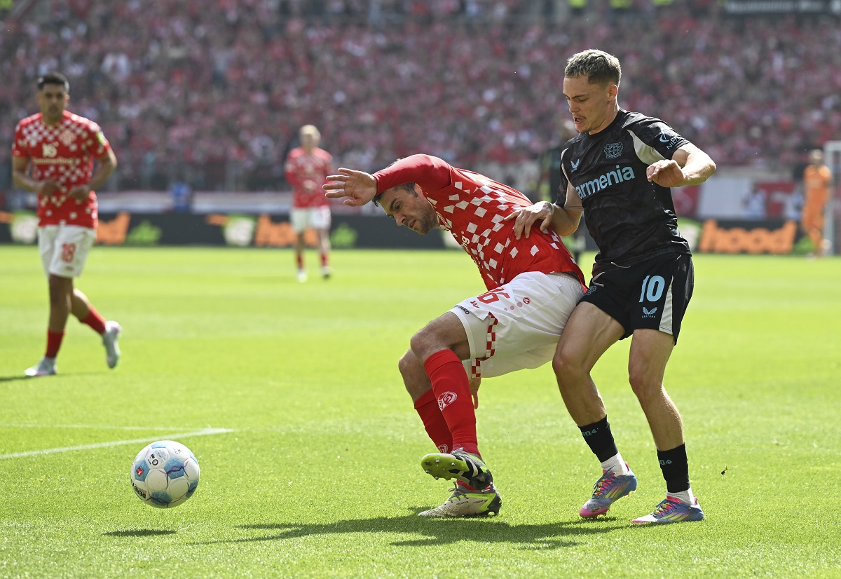 Mainz's Stefan Bell, left and Leverkusen's Florian Wirtz vie for the ball., during the German Bundesliga soccer match between 1. FSV Mainz 05 and Bayer Leverkusen, at the Mewa Arena, in Mainz, Germany, Saturday, May 17, 2025. (Arne Deder/dpa via AP)