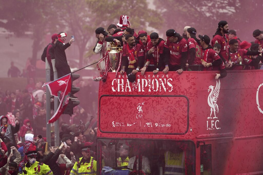Liverpool players celebrate with the trophy on an open-top bus during the Liverpool FC Premier League victory parade in Liverpool, England, Monday, May 26, 2025.(AP Photo/Jon Super)