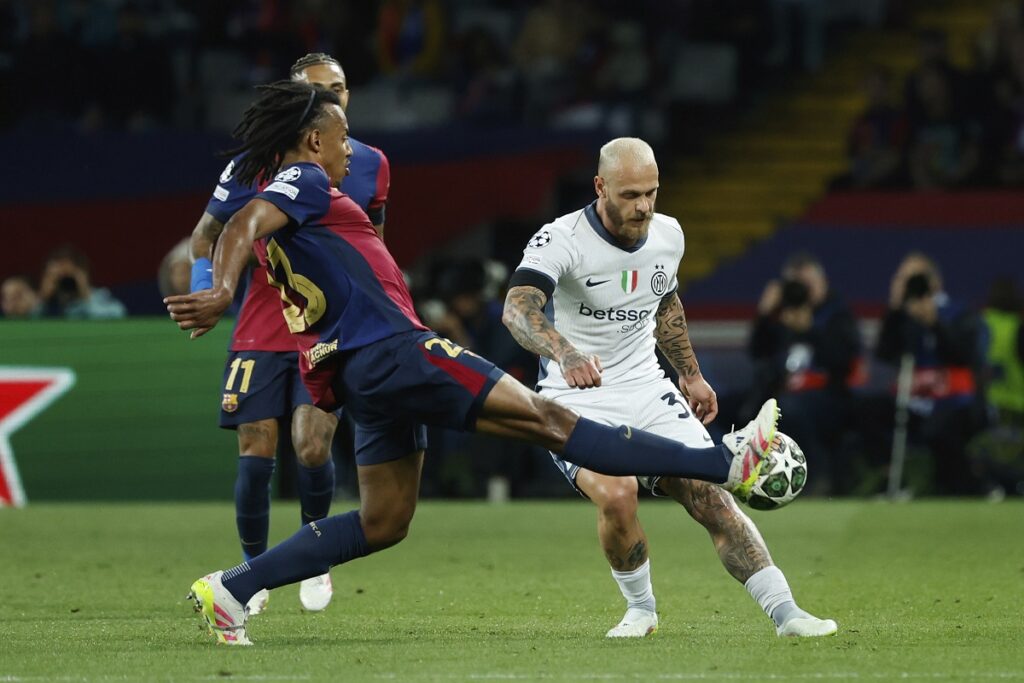 Barcelona's Jules Kounde, left, fights for the ball with Inter Milan's Federico Dimarco during the Champions League semifinal first leg soccer match between Barcelona and Inter Milan at the Lluis Companys Olympic Stadium in Barcelona, Spain, Wednesday, April 30, 2025. (AP Photo/Joan Monfort)