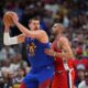 Denver Nuggets center Nikola Jokic, left, looks to pass the ball as Los Angeles Clippers forward Nicolas Batum, right, defends in the second half of Game 7 of an NBA basketball first-round playoff series Saturday, May 3, 2025, in Denver. (AP Photo/David Zalubowski)