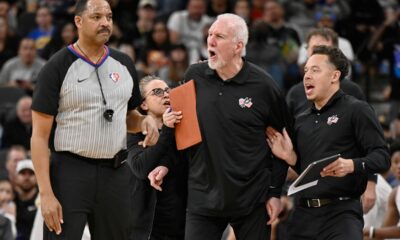 FILE - San Antonio Spurs head coach Gregg Popovich, second from right, yells at referee Bennie Adams, left, while being restrained by Spurs assistant coaches Mitch Johnson, right, and Becky Hammon during the first half of an NBA basketball game against the New Orleans Pelicans on Friday, March 18, 2022, in San Antonio. (AP Photo/Darren Abate, File)