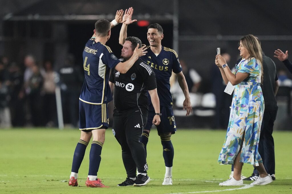 Vancouver Whitecaps defender Ranko Veselinović (4) and forward Damir Kreilach (19) celebrate after defeating Inter Miami in a CONCACAF Champions Cup second-leg semifinal soccer match, Wednesday, April 30, 2025, in Fort Lauderdale, Fla. (AP Photo/Lynne Sladky)