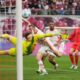 Leipzig's Lukas Klostermann, background left, scores his side's second goal past Bayern's goalkeeper Jonas Urbig during the German Bundesliga soccer match between RB Leipzig and FC Bayern Munich at the Red Bull Arena in Leipzig, Germany, Saturday, May 3, 2025. (AP Photo/Matthias Schrader)