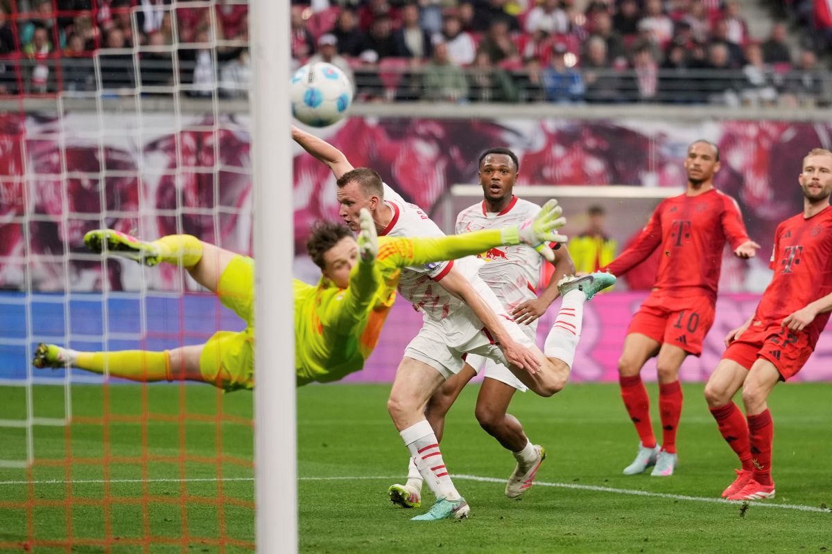 Leipzig's Lukas Klostermann, background left, scores his side's second goal past Bayern's goalkeeper Jonas Urbig during the German Bundesliga soccer match between RB Leipzig and FC Bayern Munich at the Red Bull Arena in Leipzig, Germany, Saturday, May 3, 2025. (AP Photo/Matthias Schrader)
