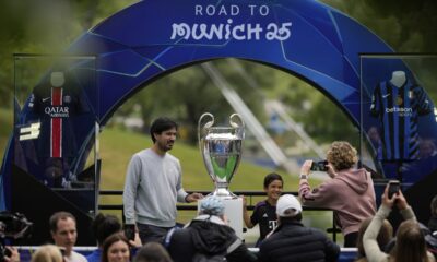 People take pictures with the trophy during the opening of the official UEFA fan festival in Munich, Germany, Thursday, May 29, 2025, ahead of the Champions League final soccer match between Inter and PSG. (AP Photo/Matthias Schrader)
