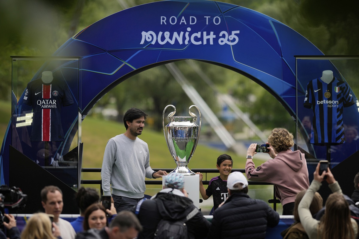 People take pictures with the trophy during the opening of the official UEFA fan festival in Munich, Germany, Thursday, May 29, 2025, ahead of the Champions League final soccer match between Inter and PSG. (AP Photo/Matthias Schrader)