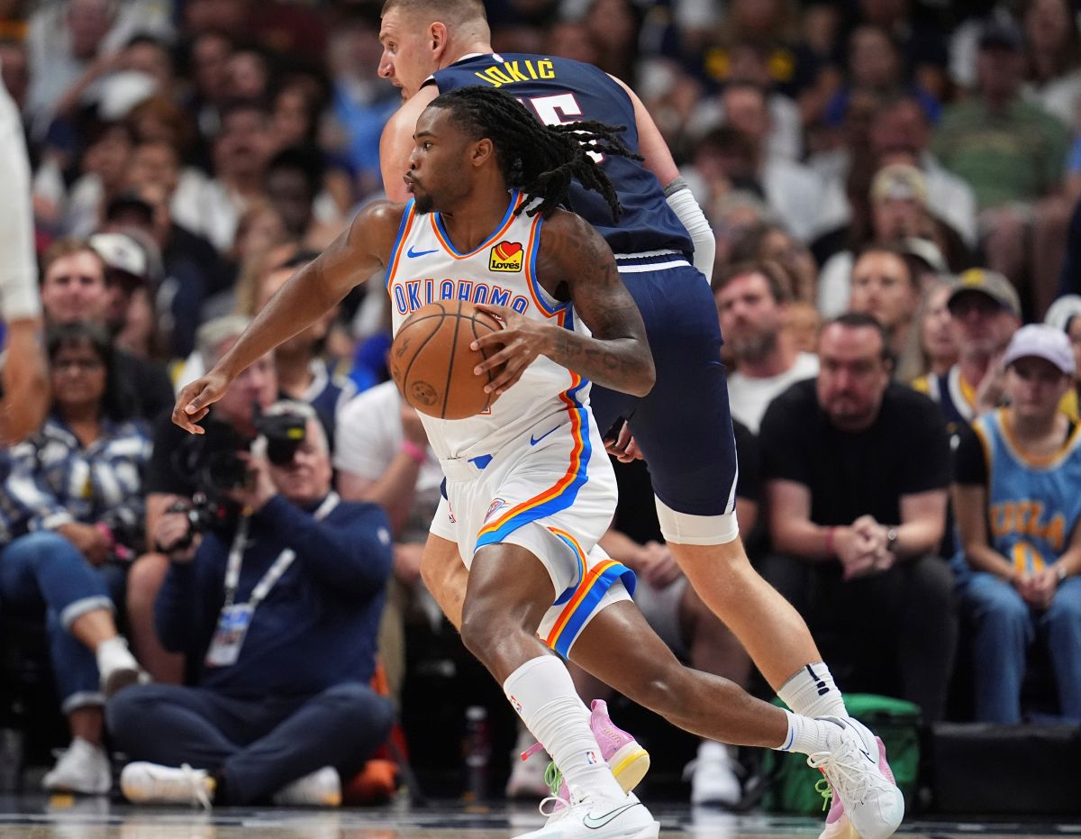 Thunder Nuggets Basketball Oklahoma City Thunder guard Cason Wallace, front, drives past Denver Nuggets center Nikola Jokic, back, in the first half of Game 4 in the Western Conference semifinals of the NBA basketball playoffs Sunday, May 11, 2025, in Denver. (AP Photo/David Zalubowski)
