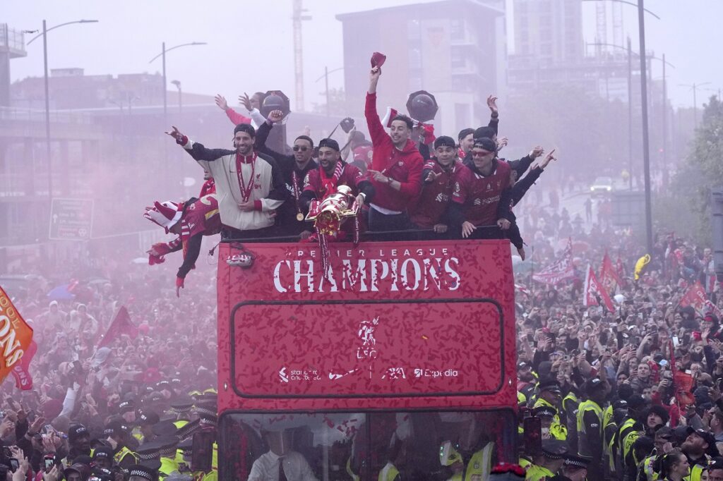 Liverpool players celebrate with the trophy on an open-top bus during the Liverpool FC Premier League victory parade in Liverpool, England, Monday, May 26, 2025.(AP Photo/Jon Super)
